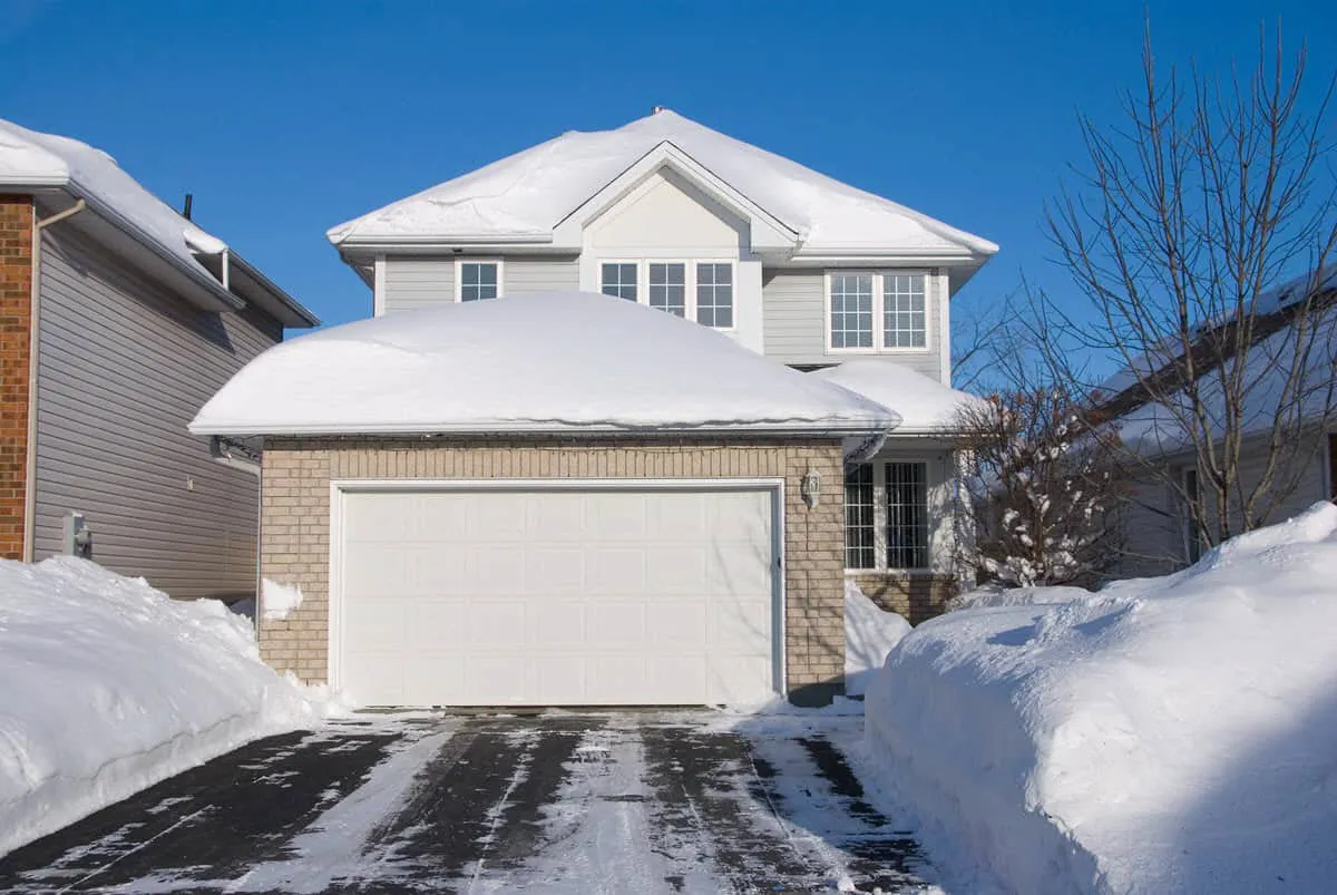Garage door in winter with snow around the base